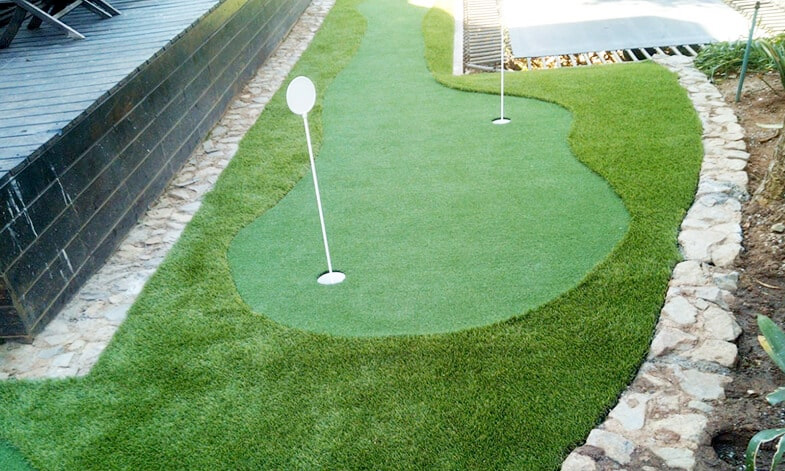 curved artificial putting green near pool with flag holes