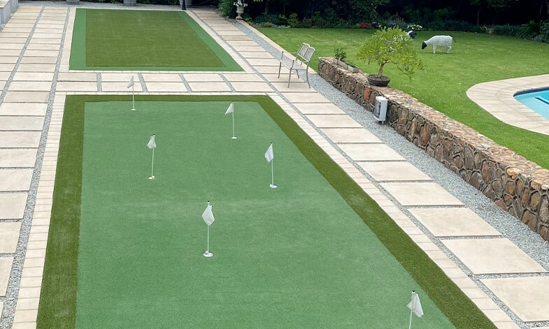 artificial chipping and putting green in residential garden near pool